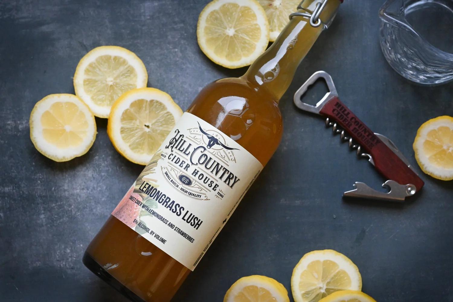 Lemongrass Lush cider bottle with lemon slices and a pitcher