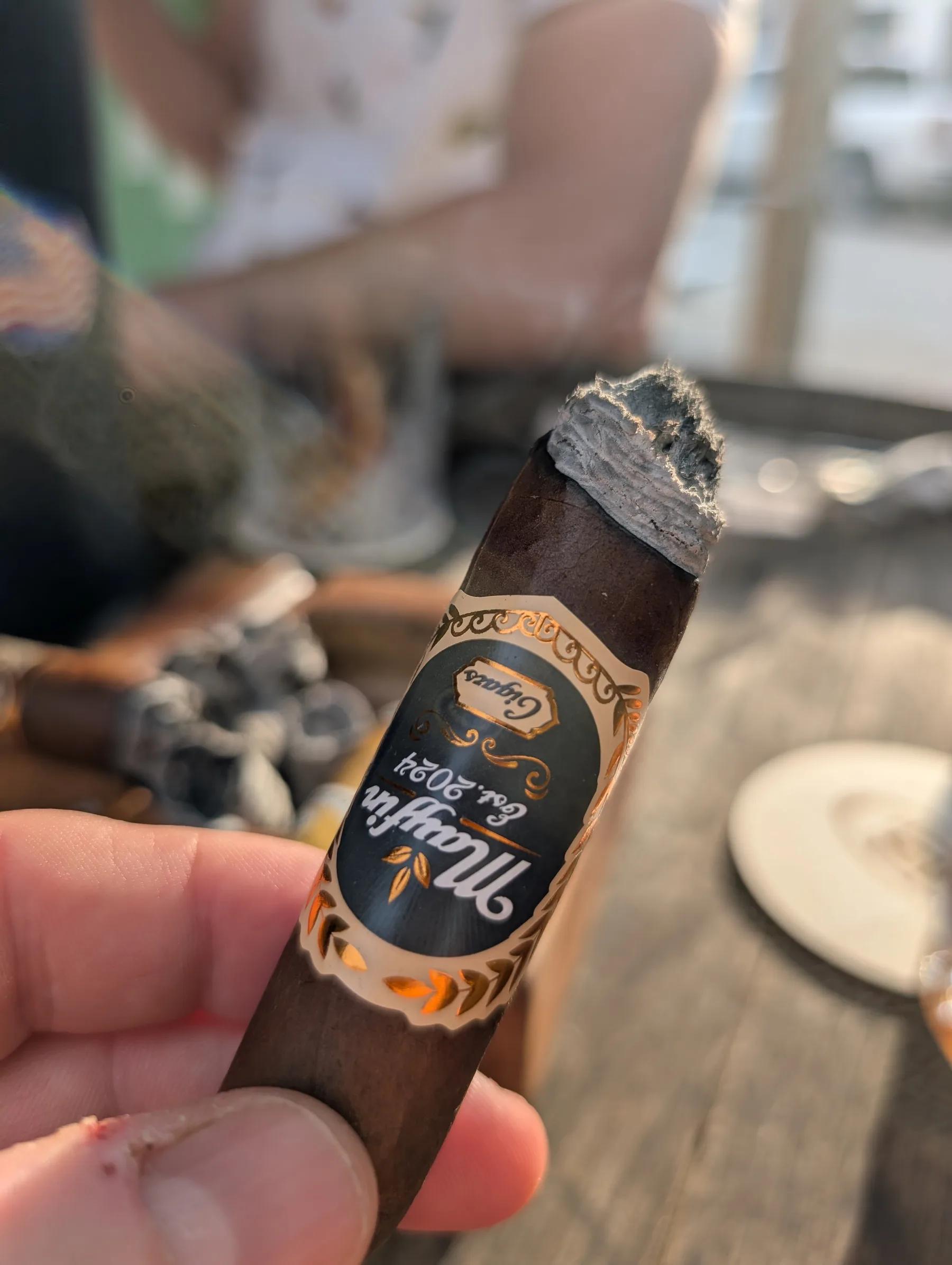 A lit Mayfin cigar showing the band